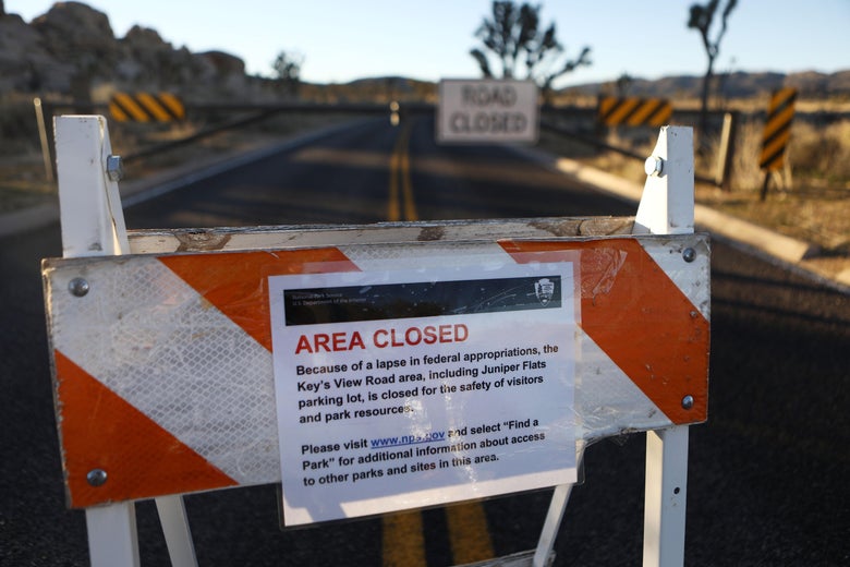 An 'Area Closed' sign is posted in front of a closed section of road at Joshua Tree National Park.